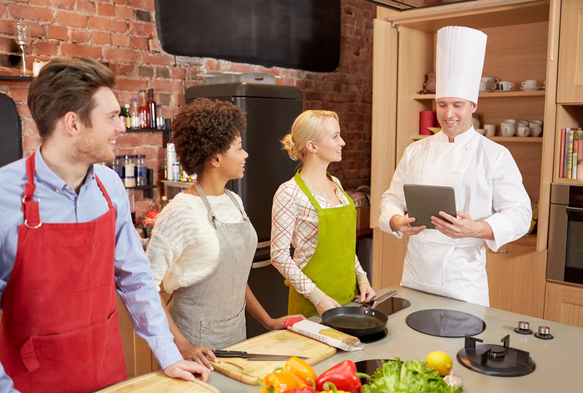 Grande immagine: chef che insegna a un gruppo in cucina